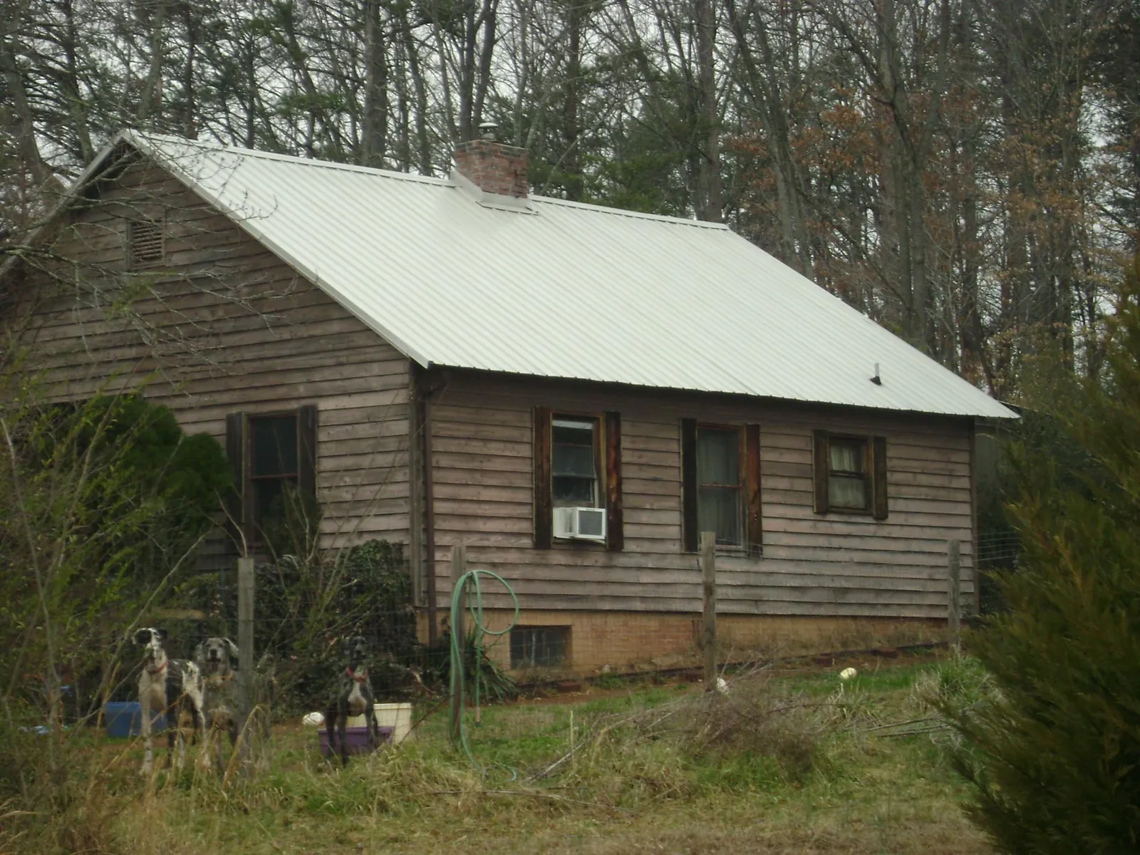 White metal roof on an old wood sided farmhouse, from a Metal Roof Installation job in Bourbon